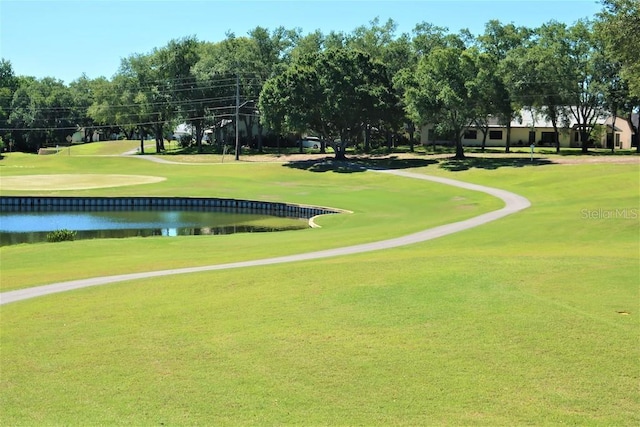 surrounding community with a yard and a water view