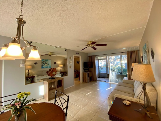 living room featuring ceiling fan, a textured ceiling, and light tile patterned floors