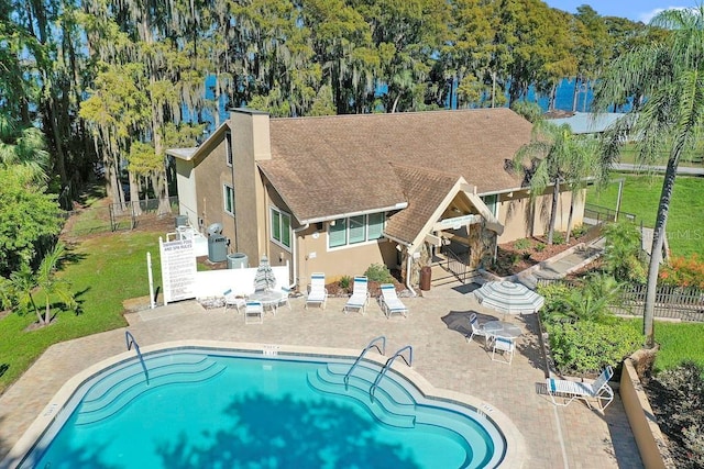 view of pool with a patio area and a lawn