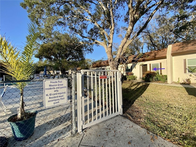 view of gate featuring a lawn