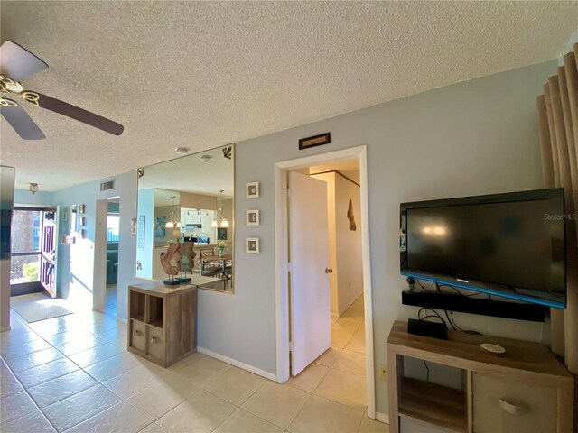 interior space featuring light tile patterned flooring, a textured ceiling, and ceiling fan