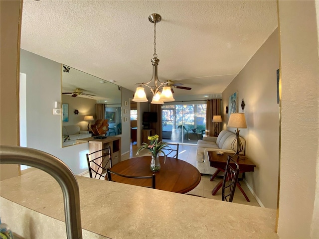 dining area with ceiling fan, a textured ceiling, and light tile patterned flooring