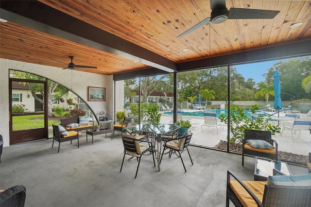 sunroom with beamed ceiling, wooden ceiling, and ceiling fan