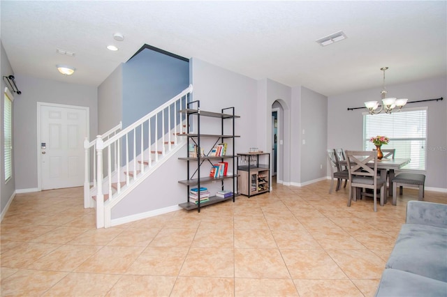 living room with an inviting chandelier and light tile patterned flooring