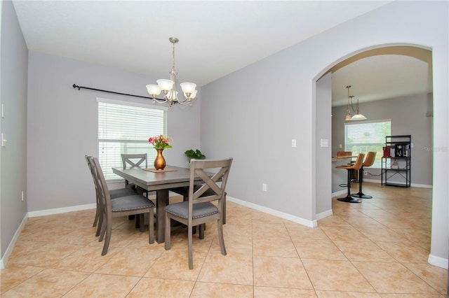 dining room with light tile patterned floors and an inviting chandelier