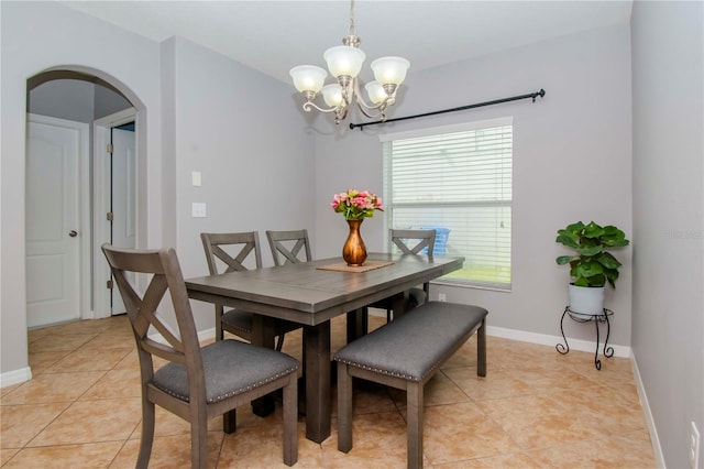 tiled dining area featuring a notable chandelier