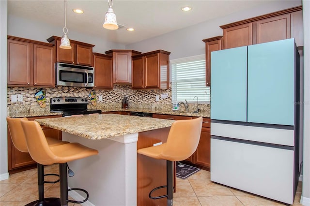 kitchen featuring a kitchen bar, a kitchen island, stainless steel appliances, and decorative backsplash