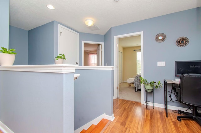 interior space with light hardwood / wood-style floors and a textured ceiling