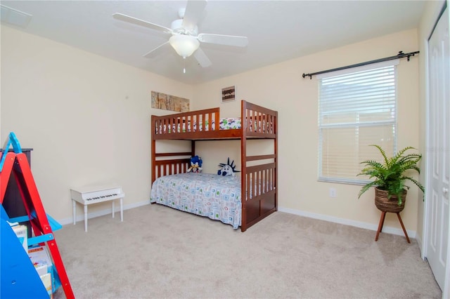 carpeted bedroom with ceiling fan and a closet