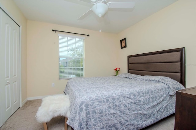 carpeted bedroom featuring ceiling fan and a closet