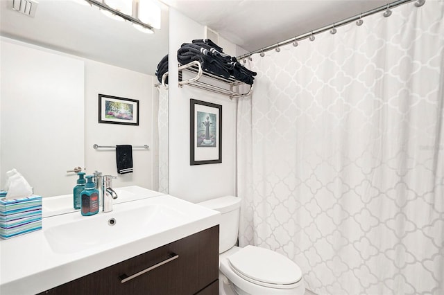 bathroom featuring a shower with shower curtain, toilet, and vanity