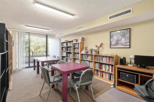 carpeted dining room with a textured ceiling