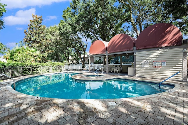 view of pool with a hot tub and a patio area