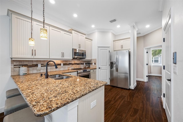 kitchen featuring backsplash, appliances with stainless steel finishes, dark hardwood / wood-style flooring, pendant lighting, and kitchen peninsula