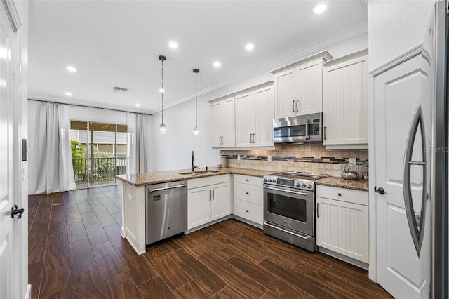 kitchen with stainless steel appliances, dark hardwood / wood-style flooring, hanging light fixtures, white cabinets, and kitchen peninsula