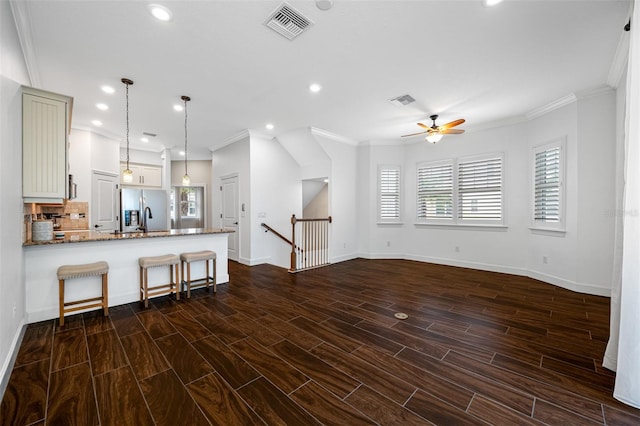 kitchen with stainless steel fridge with ice dispenser, stone counters, hanging light fixtures, dark wood-type flooring, and kitchen peninsula