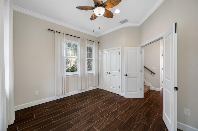 unfurnished bedroom featuring ornamental molding, ceiling fan, and a closet