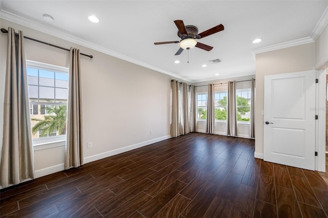 empty room featuring plenty of natural light, ceiling fan, crown molding, and dark hardwood / wood-style flooring