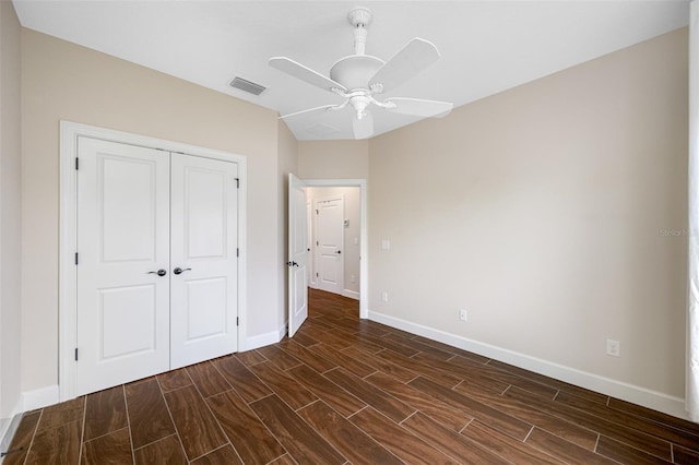 unfurnished bedroom featuring dark hardwood / wood-style flooring, ceiling fan, and a closet