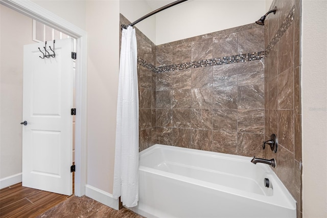 bathroom featuring hardwood / wood-style flooring and shower / bath combo with shower curtain