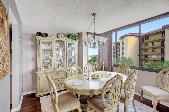 dining room featuring an inviting chandelier, a textured ceiling, and dark hardwood / wood-style flooring