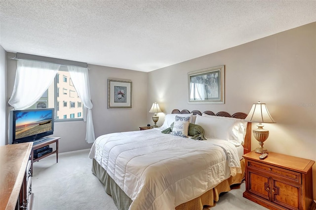 bedroom with multiple windows, a textured ceiling, and light colored carpet