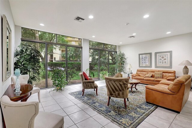 living room with a wall of windows, light tile patterned floors, and plenty of natural light