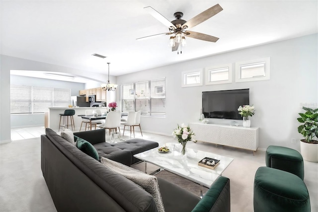 living room featuring ceiling fan with notable chandelier