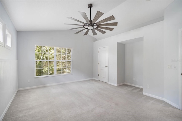 spare room with lofted ceiling, light colored carpet, and a wealth of natural light