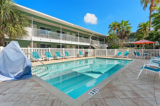 community pool featuring a patio area and fence