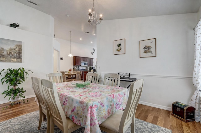 dining space featuring a notable chandelier and light hardwood / wood-style floors