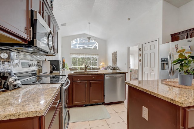 kitchen with light tile patterned floors, a center island, sink, light stone countertops, and appliances with stainless steel finishes