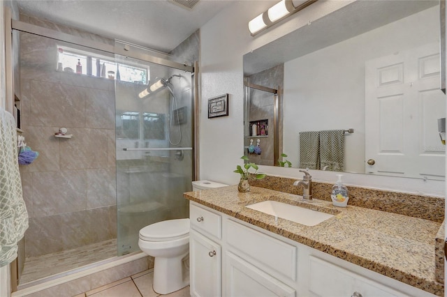 bathroom featuring vanity, toilet, an enclosed shower, and tile patterned floors