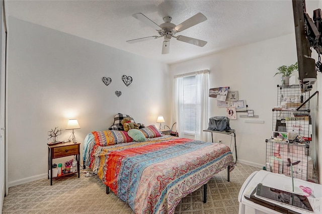 carpeted bedroom with a textured ceiling and ceiling fan