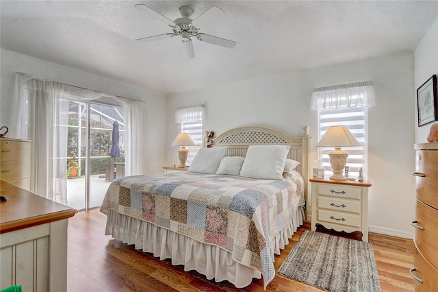 bedroom featuring a textured ceiling, access to exterior, ceiling fan, and hardwood / wood-style floors