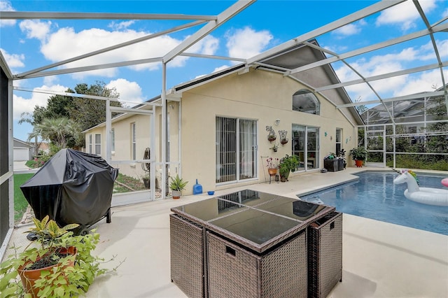 view of swimming pool featuring glass enclosure, grilling area, and a patio