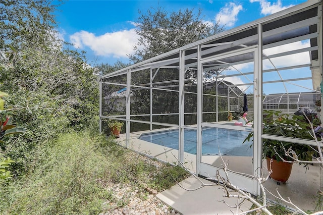 view of pool featuring glass enclosure