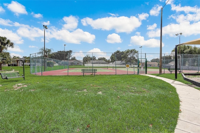 view of property's community featuring tennis court and a lawn