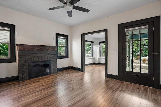 unfurnished living room featuring a fireplace, hardwood / wood-style floors, and a textured ceiling