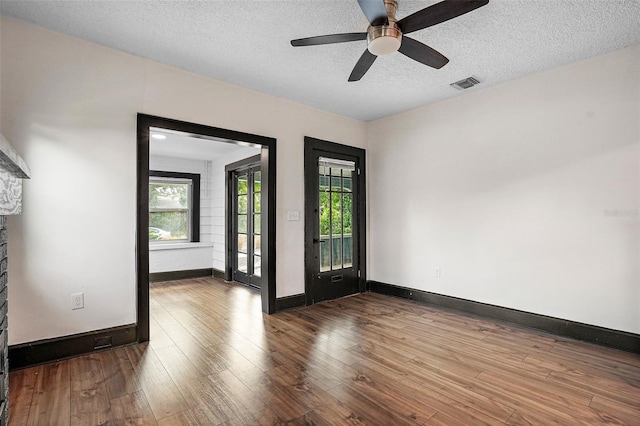 unfurnished room with hardwood / wood-style flooring, ceiling fan, and a textured ceiling