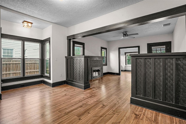 interior space featuring hardwood / wood-style floors, ceiling fan, and a textured ceiling