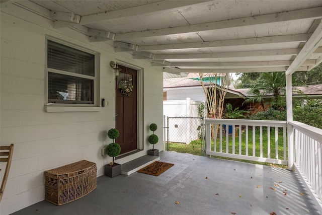 entrance to property featuring a porch and concrete block siding