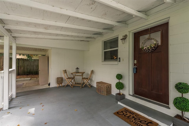 view of exterior entry featuring a patio and concrete block siding
