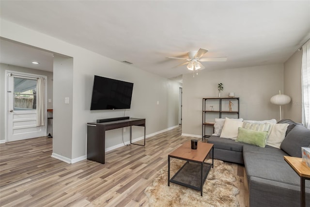 living room featuring wood finished floors, ceiling fan, baseboards, and visible vents