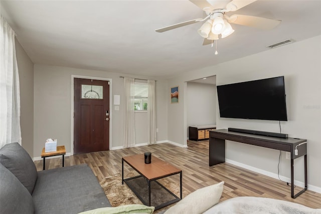 living area with wood finished floors, baseboards, a ceiling fan, and visible vents