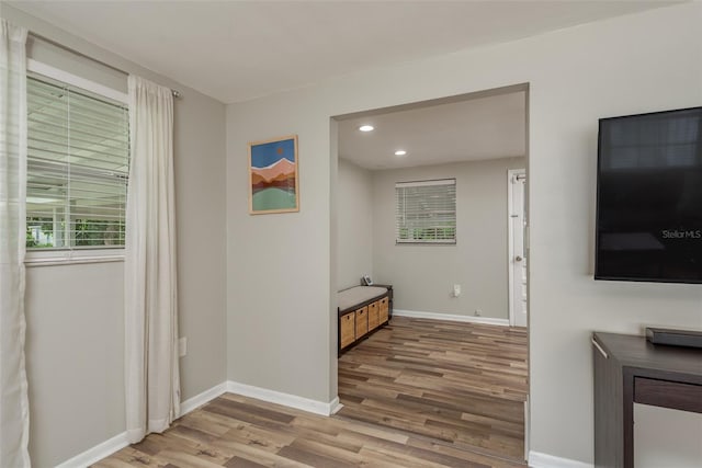 hallway with wood finished floors, baseboards, and recessed lighting
