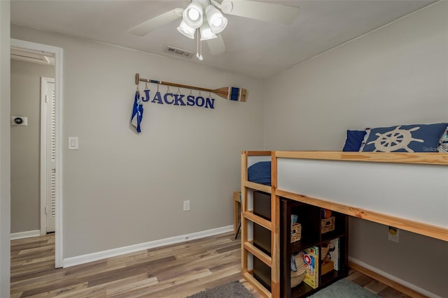 bedroom with visible vents, baseboards, a ceiling fan, and wood finished floors