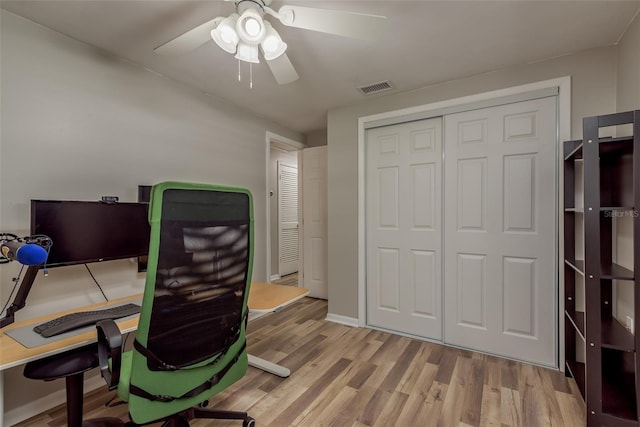 home office featuring visible vents, baseboards, a ceiling fan, and wood finished floors