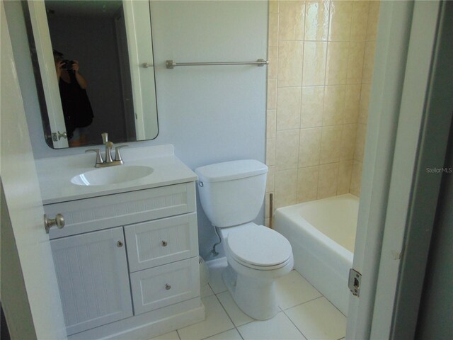 bathroom with toilet, vanity, and tile patterned floors