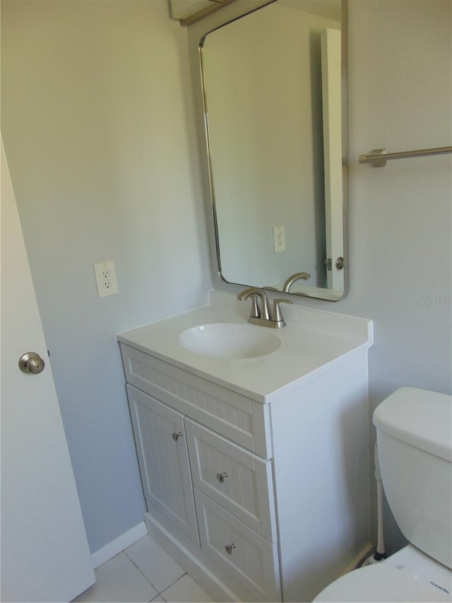 bathroom with tile patterned flooring, vanity, and toilet